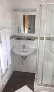 a white bathroom with a sink and a shower at Pension Weber in Vienna +13 photos
