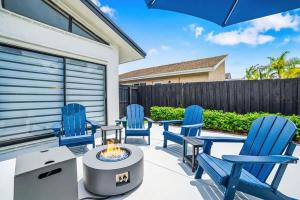a patio with blue chairs and a fire pit at Pool - BBQ - Fire pit - Pool Table - TV room in Miami