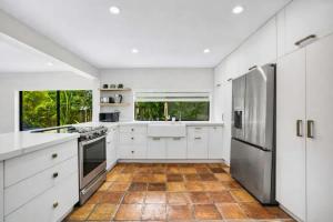 a kitchen with white cabinets and stainless steel appliances at Pool - BBQ - Fire pit - Pool Table - TV room in Miami