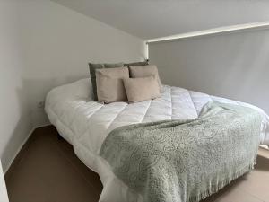 a bedroom with a white bed with pillows on it at Casa Ducrate by Asterisco Secular in Crato