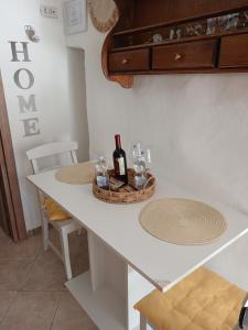 a white table with a bottle of wine on it at Maison della Madia in Triggiano