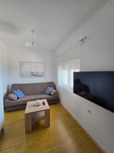 a living room with a couch and a large flat screen tv at Apartment Loza Senj in Senj