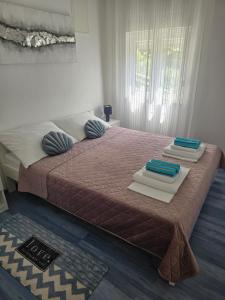 a bedroom with a large bed with towels on it at Apartment Loza Senj in Senj