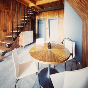 a dining room with a wooden table and white chairs at Vrleti Tare in Bajina Bašta