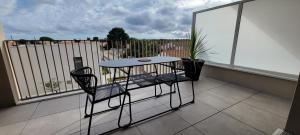 a balcony with two chairs and a table on a balcony at L'Appar-TMN in Challans
