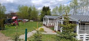 a backyard with a playground and a house at Domek LENA in Giżycko