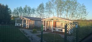 a small house with a fence in a yard at Domek LENA in Giżycko