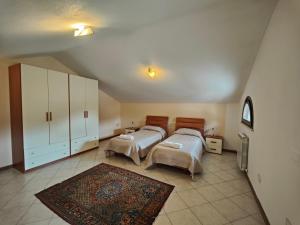 a bedroom with two beds and a rug at Residence con Piscina Vista Monte Nerone in Piobbico +15 photos