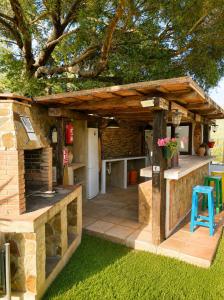an outdoor kitchen with a stone building with a wooden roof at La casa de Rodrigo y Manuela in Tarifa +2 photos