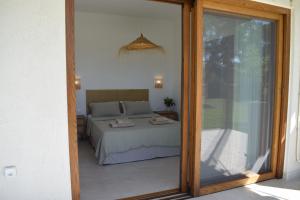 a bedroom with a bed and a sliding glass door at Guesthouse Morito in Ierissos