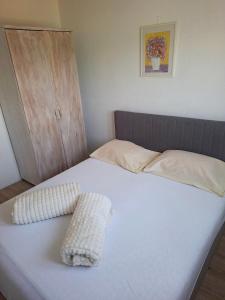 a bed with two pillows on top of it at Vikendica Vlahić, Goranci in Mostar