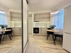 a kitchen and dining room with two tables and chairs at Home sweet home 2 in Chişinău