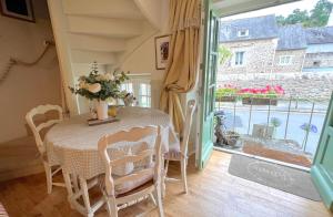 a dining room with a table and chairs and a window at La Petite Madeleine is a Charming 2 Bedroom Pet Friendly Gite situated on Dinan Port in Dinan