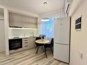 a kitchen with a small table and a refrigerator at Home sweet home 2 in Chişinău