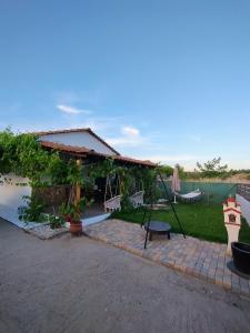a house with a patio with a swing at Tiny Loft House in Halkidiki in Nea Potidaea
