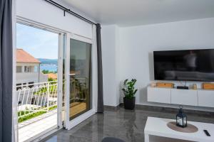 a living room with a large sliding glass door with a tv at Apartments Marina in Orebić