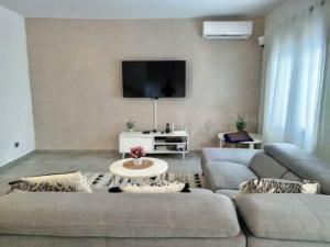 a living room with two couches and a tv at Villa Bamba TERANGA in Somone