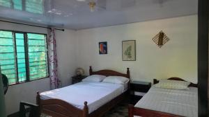 a bedroom with two beds and a window at Cabinas del Mar in Sámara