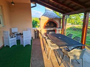 a patio with a table and chairs and a fireplace at Vikendica Vlahić, Goranci in Mostar +10 photos