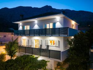 a white house with a balcony at night at Apartments Marina in Orebić