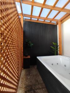 a bathroom with a large white tub and a black wall at Casa Marina Sotomayor in Santiago