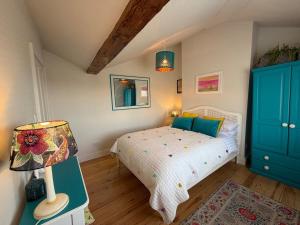 a bedroom with a bed with blue cabinets and a lamp at Charming Town House Central Margate in Margate