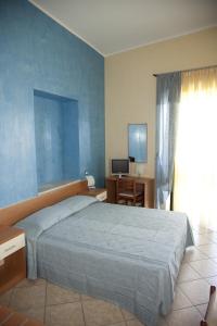 a bedroom with a large bed and a television at il portico dei normanni in Butera