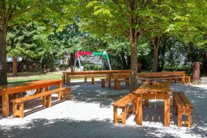 a group of picnic tables in a park with a playground at Gästehaus am Wasserpark in Rust