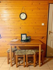 a table with a clock on a wooden wall at Apartmány Harmónia in Veľký Meder
