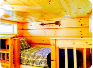 a bedroom in a log cabin with a bed in it at Peaceful Forest Tiny Home in Newport
