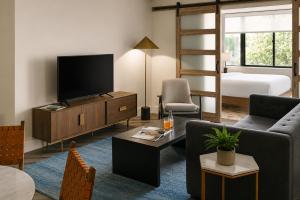 a living room with a television and a bed at Bluebird Suites at Georgetown in Washington, D.C.