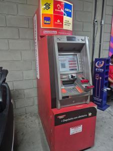 a red atm machine sitting next to a wall at Repouso Box in Cabo de Santo Agostinho