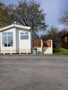 a small white shed with a door and windows at The Cosy Nook in Launceston