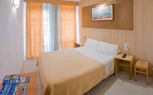 1 dormitorio con 1 cama y 1 mesa con mesita de noche en Pensión Venecia en Salou