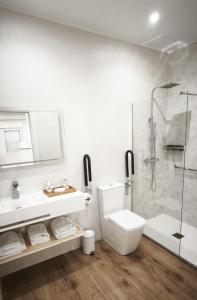 a white bathroom with a toilet and a shower at Pensión Vázquez in Vimianzo +33 photos