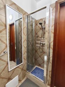 a shower in a bathroom with two mirrors at baia verde holiday in Baia Verde