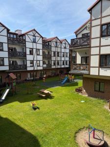 an apartment complex with a playground in the yard at Apartament pod Dębami in Rowy