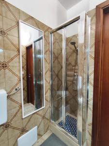a shower in a bathroom with two mirrors at baia verde holiday in Baia Verde