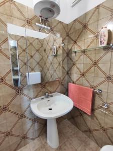 a bathroom with a white sink and a mirror at baia verde holiday in Baia Verde +5 photos