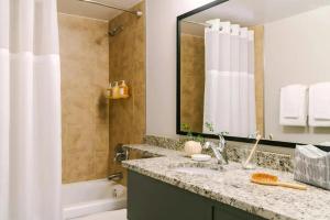 a bathroom with a sink and a tub and a mirror at Bluebird Suites at Georgetown in Washington, D.C. +30 photos