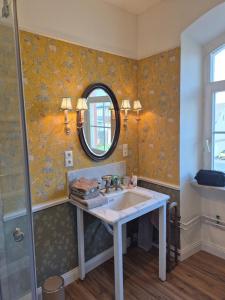 a bathroom with a sink and a mirror at Old Parish Hall, Waldeck Castle in Beltheim +24 photos