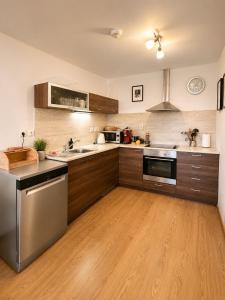 a kitchen with wooden cabinets and stainless steel appliances at Ski IN-OUT Apartmán Donovaly in Donovaly +15 photos
