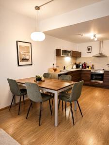 a kitchen and dining room with a wooden table and chairs at Ski IN-OUT Apartmán Donovaly in Donovaly