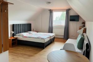 a bedroom with a bed and a table and a window at Pokoje Gościnne AKACJA in Swornegacie