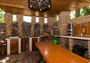 a kitchen with a wooden table and a stone wall at Дача in Kurortne