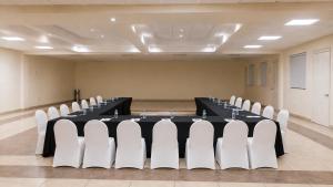 a conference room with a black table and white chairs at Hotel Cortez Baja Inn, Ensenada in Ensenada +32 photos