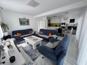 a living room with blue couches and a table at AM Una Lux House in Bihać