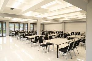 a large room with tables and chairs and windows at GRIG Villa & Hotel in Stepʼanavan
