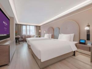 a hotel room with two beds and a flat screen tv at Mercure Beijing Anzhen Olympic Center in Beijing +62 photos