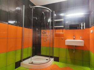 a colorful bathroom with a shower and a sink at Gloria in Olomouc